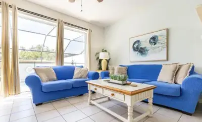 a living room with blue couches and a coffee table at Disney Home in Orlando