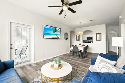 a living room with a blue couch and a table at Perfect Disney Resort Condo in Kissimmee