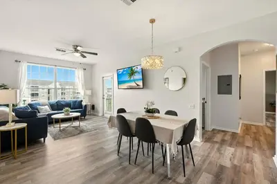 a living room and dining room with a table and chairs at Perfect Disney Resort Condo in Kissimmee