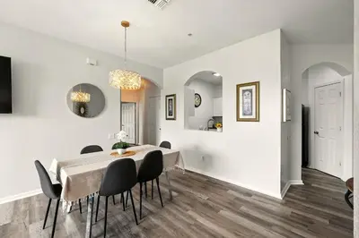 a dining room with white walls and a table and chairs at Perfect Disney Resort Condo in Kissimmee