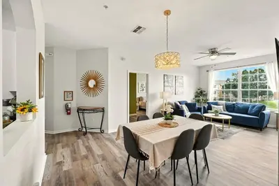 a living room with a table and a blue couch at Perfect Disney Resort Condo in Kissimmee