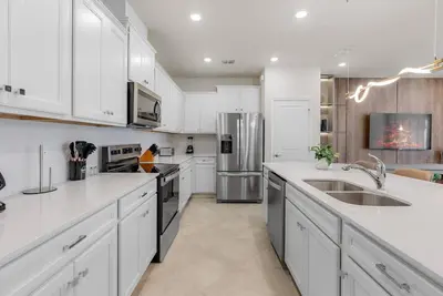 a kitchen with white cabinets and stainless steel appliances at Brand NEW 05 Bedrooms At Windsor Cay in Orlando
