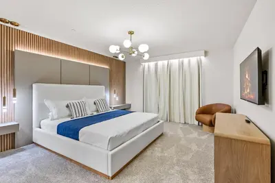 a white bedroom with a large bed and a chair at Brand NEW 05 Bedrooms At Windsor Cay in Orlando