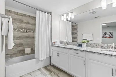 a bathroom with two sinks and a tub and a shower at Brand NEW 05 Bedrooms4 Baths At Storey Lake in Kissimmee