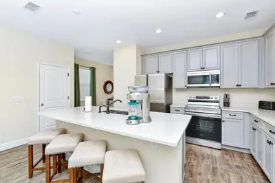 a kitchen with white cabinets and a white counter top at Paradise Breeze Cottage by Shine Villas - Margaritaville Resort Orlando condo in Orlando