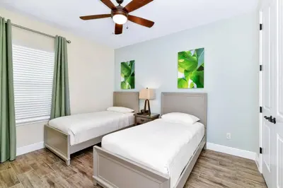 two beds in a bedroom with a ceiling fan at Paradise Breeze Cottage by Shine Villas - Margaritaville Resort Orlando condo in Orlando