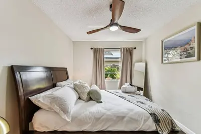 a bedroom with a bed with a ceiling fan at Relaxing Modern Home Sleeps 6 Pool BBQ Firepit in Sorrento