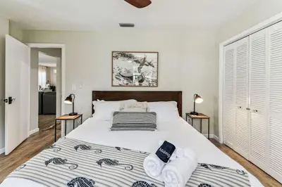 a bedroom with a large bed with two lamps at Relaxing Modern Home Sleeps 6 Pool BBQ Firepit in Sorrento