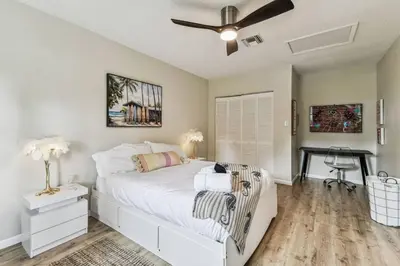 a bedroom with a white bed and a desk at Relaxing Modern Home Sleeps 6 Pool BBQ Firepit in Sorrento