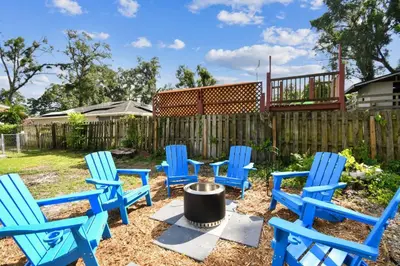 a group of blue chairs sitting in a yard at Relaxing Modern Home Sleeps 6 Pool BBQ Firepit in Sorrento