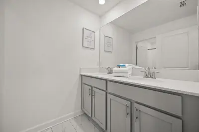 a white bathroom with a sink and a mirror at 4 Bedrooms 3 Bathrooms Storey Lake 2952 Ps in Kissimmee