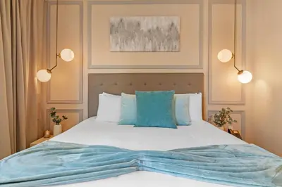 a bedroom with a bed with blue pillows at 4 Bedrooms 45 Bathrooms Magic Village7603Rd in Orlando