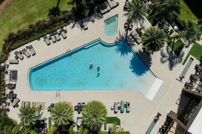 an overhead view of a swimming pool with two people in it at 4 Bedrooms 45 Bathrooms Magic Village7603Rd in Orlando