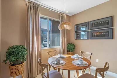 a dining room with a table and chairs and a window at 4 Bedrooms 45 Bathrooms Magic Village7603Rd in Orlando