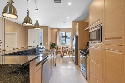 a kitchen with stainless steel appliances and wooden cabinets at 4 Bedrooms 45 Bathrooms Magic Village7603Rd in Orlando