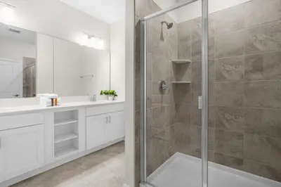 a white bathroom with a shower and a sink at 2 Bedrooms 2 Bathrooms Storey Lake 3151-404 in Kissimmee
