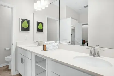 a white bathroom with two sinks and a mirror at 2 Bedrooms 2 Bathrooms Storey Lake 3151-404 in Kissimmee