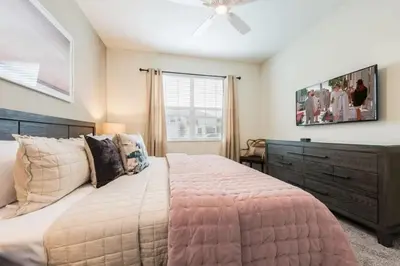 a bedroom with a large bed and a ceiling fan at Refúgio de Luxo 6 quartos c/ piscina aquecida in Kissimmee