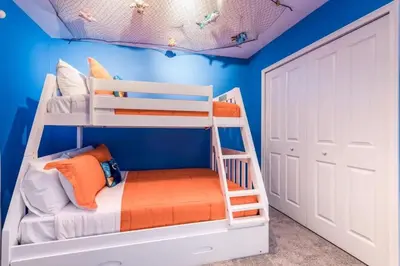 a room with two bunk beds and a blue wall at Refúgio de Luxo 6 quartos c/ piscina aquecida in Kissimmee