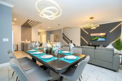 a dining table and chairs in a living room at Private Pool - Themed Rooms - Near Disney 4239 in Kissimmee