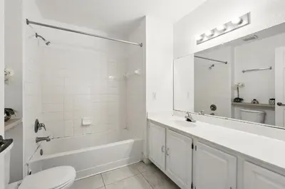a white bathroom with a tub and a sink and a toilet at Your Orlando Escape - Gated Resort with Amenities in Kissimmee