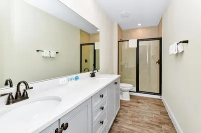 a bathroom with two sinks and a toilet at Paradise Breeze Cottage By Shine Villas Margaritaville Resort Orlando in Orlando