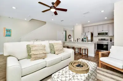 a living room with a white couch and a ceiling fan at Paradise Breeze Cottage By Shine Villas Margaritaville Resort Orlando in Orlando