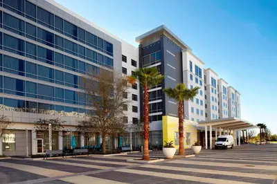 a large building with palm trees in front of it at Courtyard by Marriott Orlando Lake Nona in Orlando