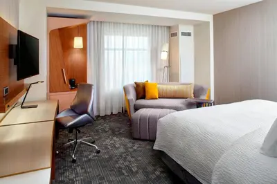 a hotel room with a bed and a chair at Courtyard by Marriott Orlando Lake Nona in Orlando