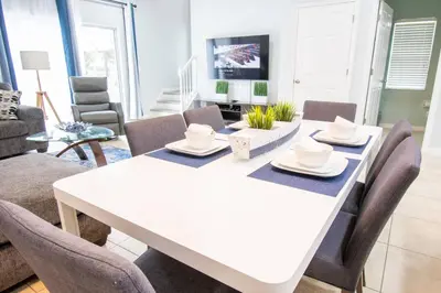 a dining room with a white table and chairs at NEW - Townhome on amazing resort - private hot tub in Kissimmee