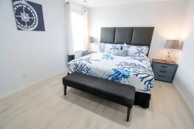 a bedroom with a bed with a blue and white comforter at NEW - Townhome on amazing resort - private hot tub in Kissimmee