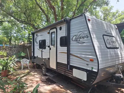 an rv parked in a yard under a tree at Tiny Trailer happy hole in the wall in Orlando