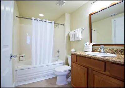 a bathroom with a toilet and a sink and a shower at Calypso Cay Vacation Villas in Kissimmee