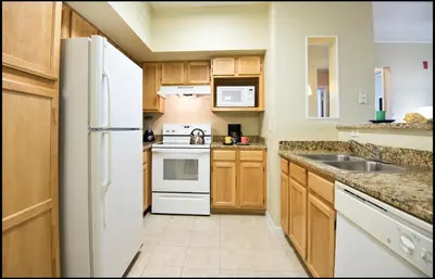 a kitchen with a white refrigerator and a sink at Calypso Cay Vacation Villas in Kissimmee