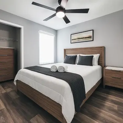 a bedroom with a large bed with a ceiling fan at 3BD Townhome with Pool 12mi to Disney and Universal in Kissimmee