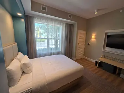 a bedroom with a large bed and a large window at Go 29 Margaritaville Studio in Orlando