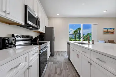 a kitchen with white cabinets and a large window at Bright And Beachy Villa Near Disney With Margaritaville Resort And Island H20 Waterpark Access - 3012Cs in Orlando