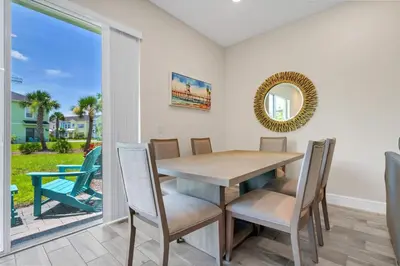 a dining room with a table and chairs and a window at Bright And Beachy Villa Near Disney With Margaritaville Resort And Island H20 Waterpark Access - 3012Cs in Orlando