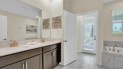 a bathroom with a sink and a mirror and a tub at Parfect Paradise in Orlando