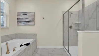 a white bathroom with a tub and a shower at Parfect Paradise in Orlando
