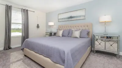 a bedroom with a large bed and a window at Storey Lake Retreat in Kissimmee