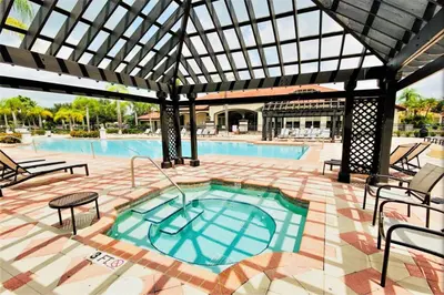 a large swimming pool with a large pergola at Resort 4 Br 3 Ba Private Pool Home & Lake View near Disney & Universal in Kissimmee