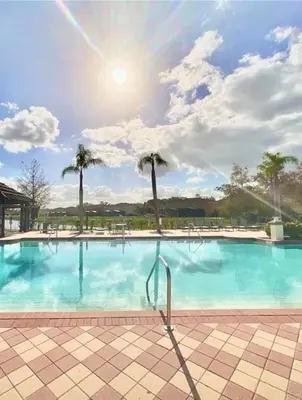a large swimming pool with palm trees in the background at Resort 4 Br 3 Ba Private Pool Home & Lake View near Disney & Universal in Kissimmee