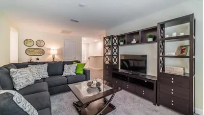 a living room with a couch and a tv at The Sunshine Villa in Kissimmee
