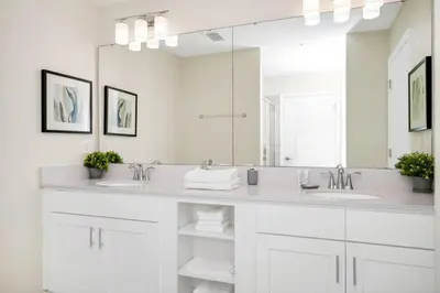 a white bathroom with two sinks and a large mirror at 2BR Family Condo Near Disney, Universal and More in Kissimmee