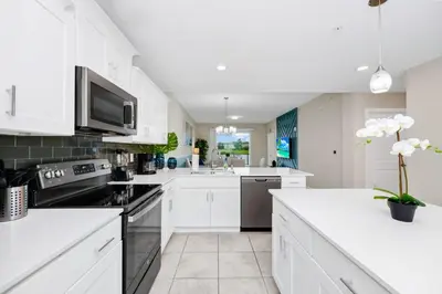 a kitchen with white cabinets and a white counter top at 2BR Family Condo Near Disney, Universal and More in Kissimmee