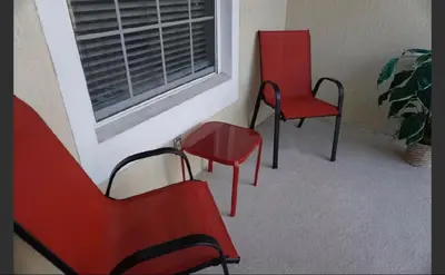 three red chairs and a window in a room at Apartment near Disney & UniversalEpic in Orlando