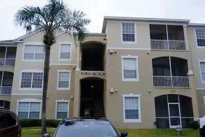 a house with a palm tree in front of it at Apartment near Disney & UniversalEpic in Orlando