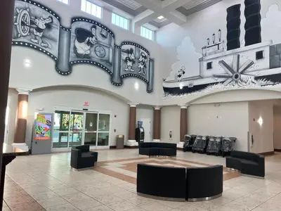 a large lobby with black chairs and a staircase at Condo near Disney-free shuttle to all theme parks in Orlando