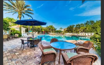 a patio with a table and chairs and a pool at Condo Disney Universal Epic Pool in Kissimmee